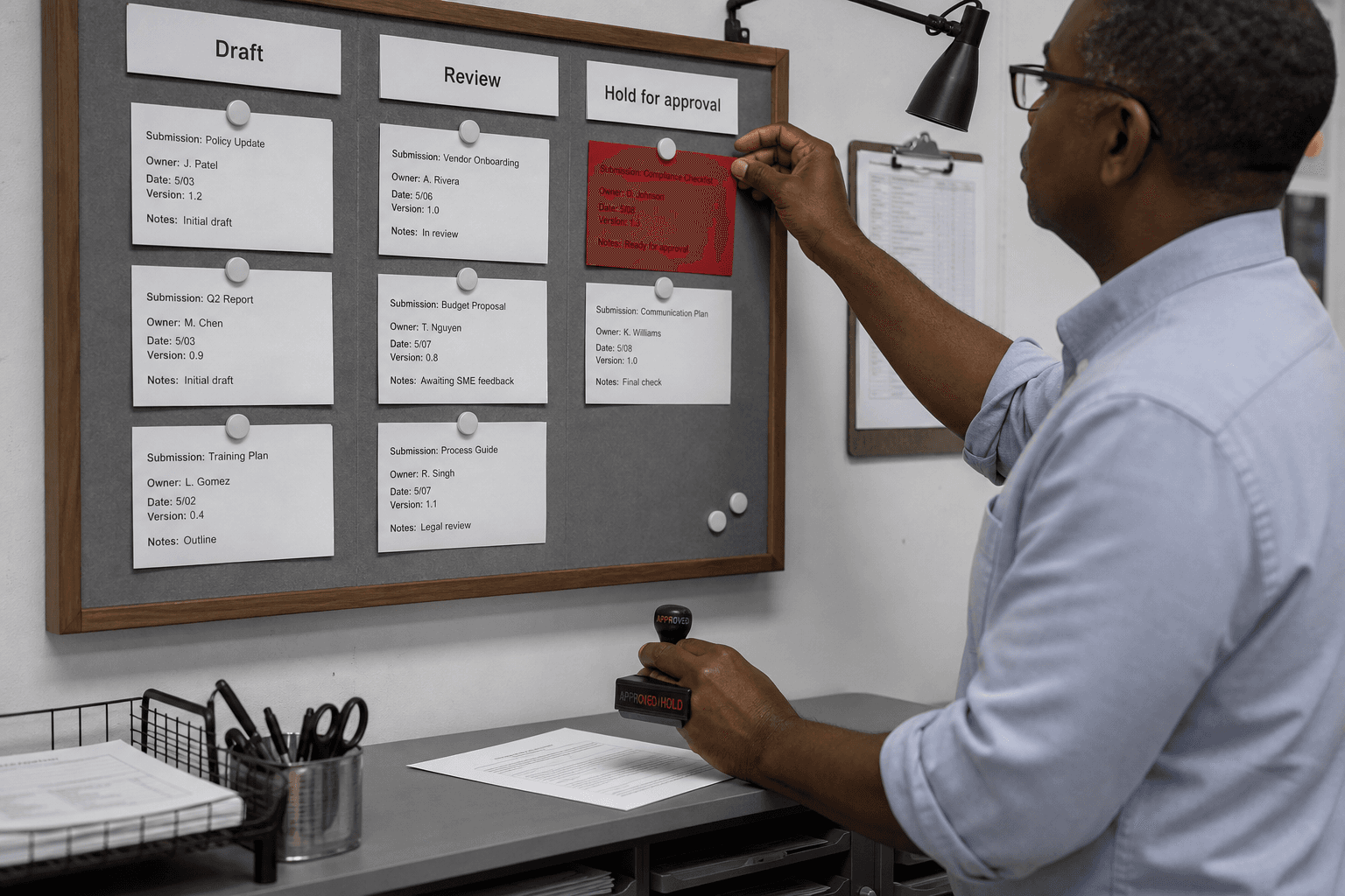 An operator at a wall review board placing a hold card and stamping an approval decision.