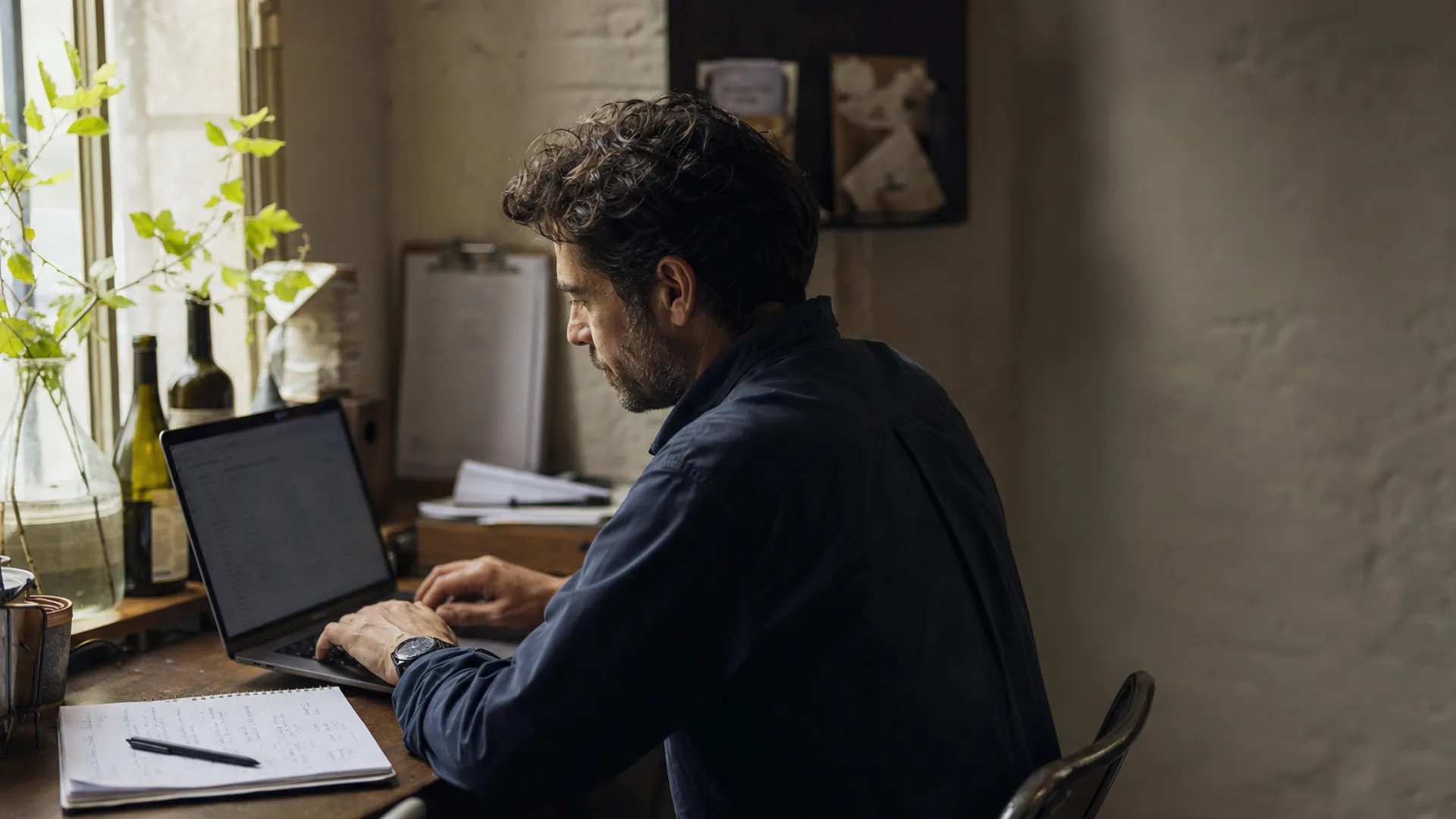 Restaurant owner reviews weekly admin tasks on a laptop at a quiet back-office desk before service