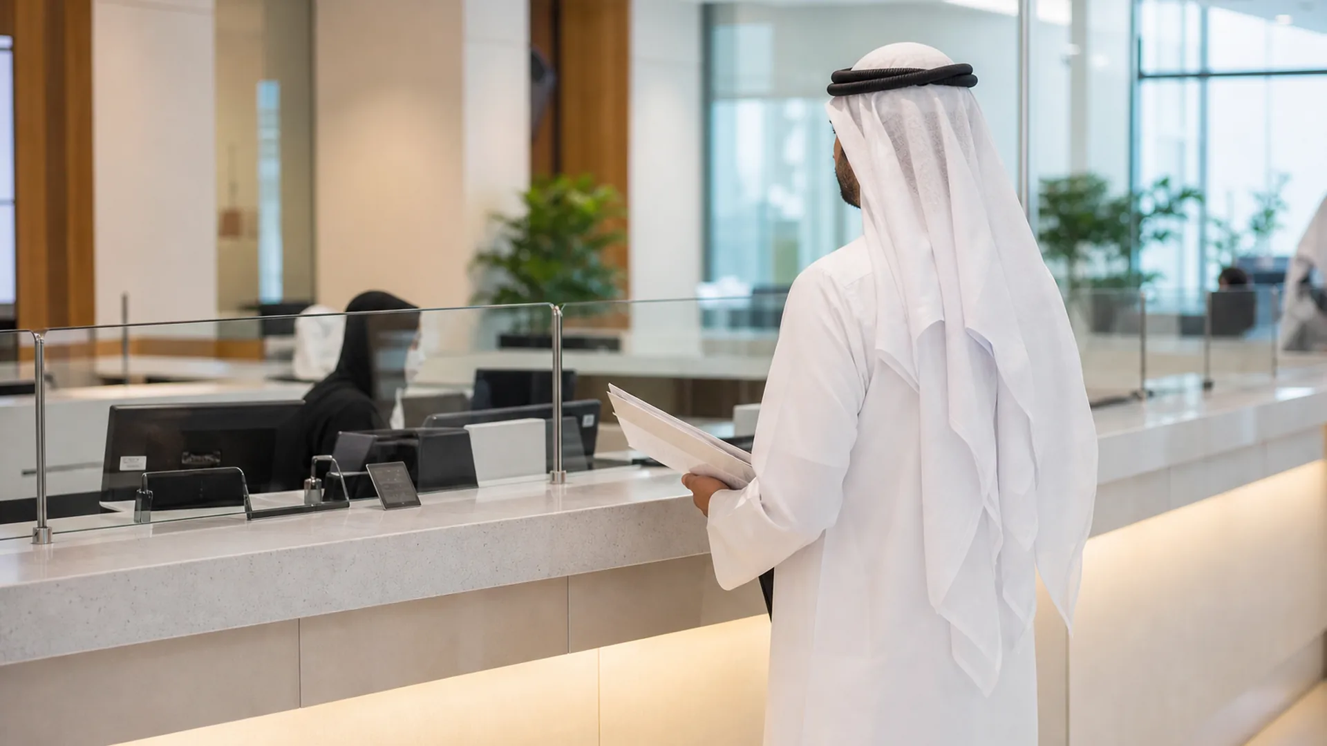 Visitor at a commercial registration service counter with licensing paperwork